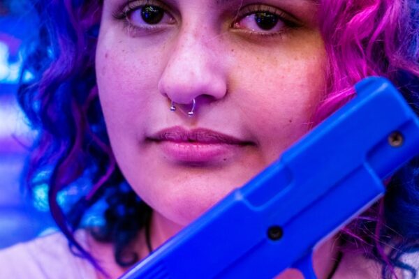 Neon hair female with training pistol