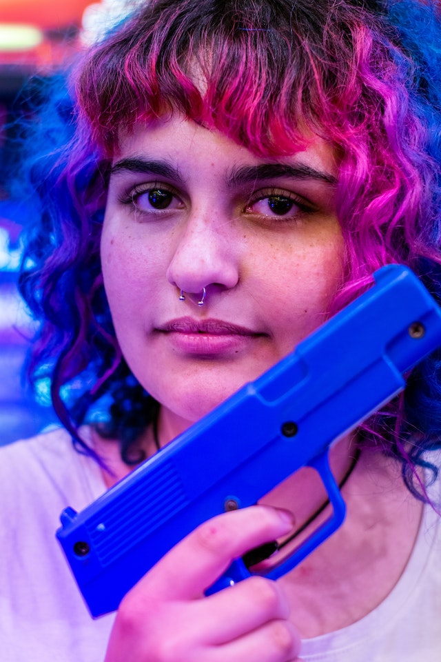 Neon hair female with training pistol