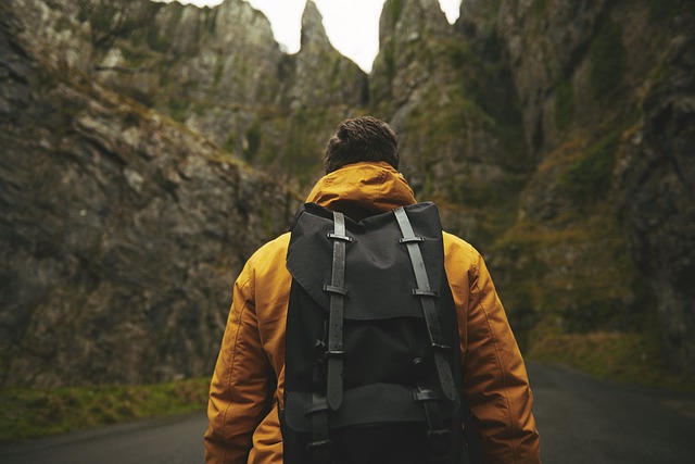 Man with backpack walking into the woods.