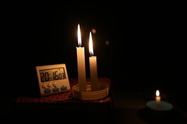 Candles in a dark room on bedside table.